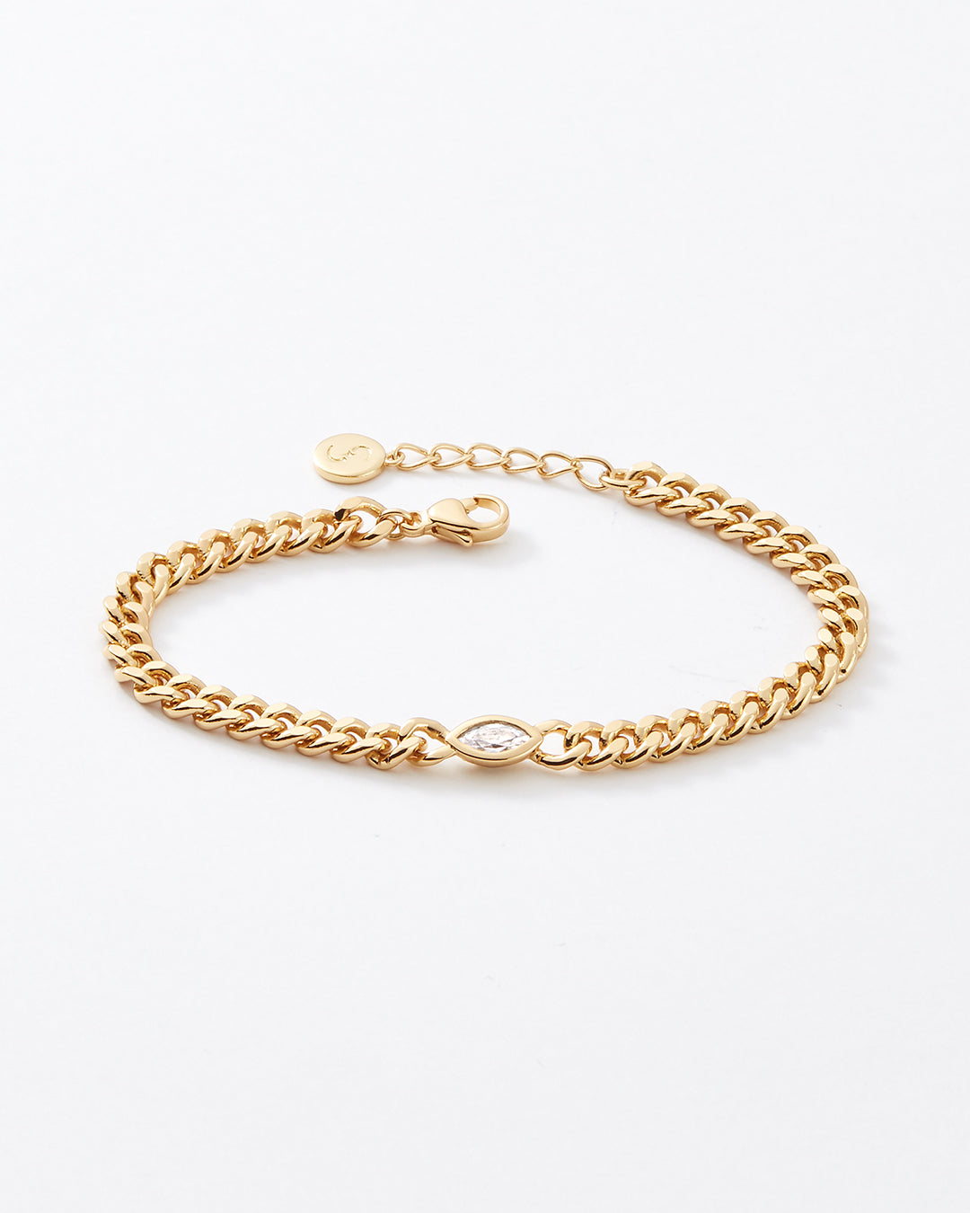 A gold-toned chain bracelet with a curb-style link design, a small oval topaz gemstone charm, and an extender chain with a lobster clasp, photographed on a clean white background.