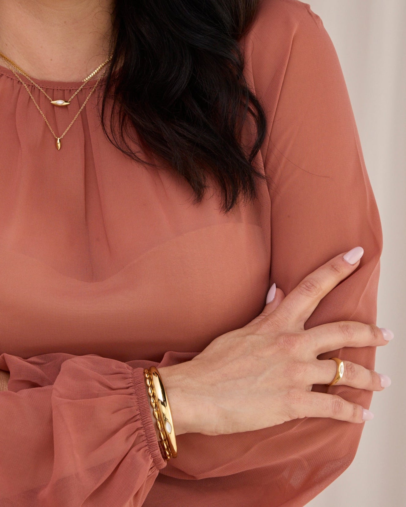 Two layered cuff bracelets., one is a dome shape the other is a beaded shape.