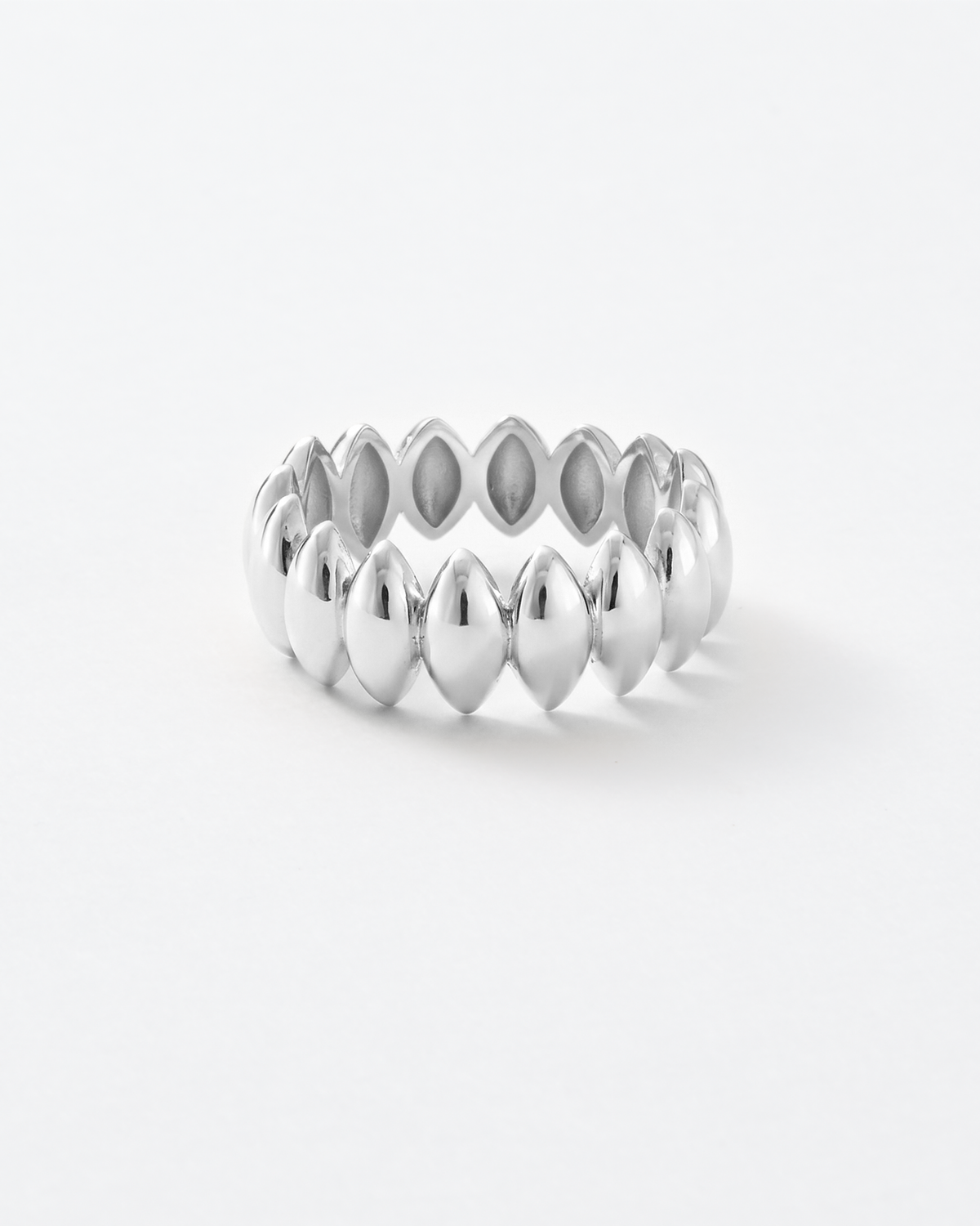A silver band ring featuring a series of polished, petal-shaped metallic patterns, photographed on a seamless white background.