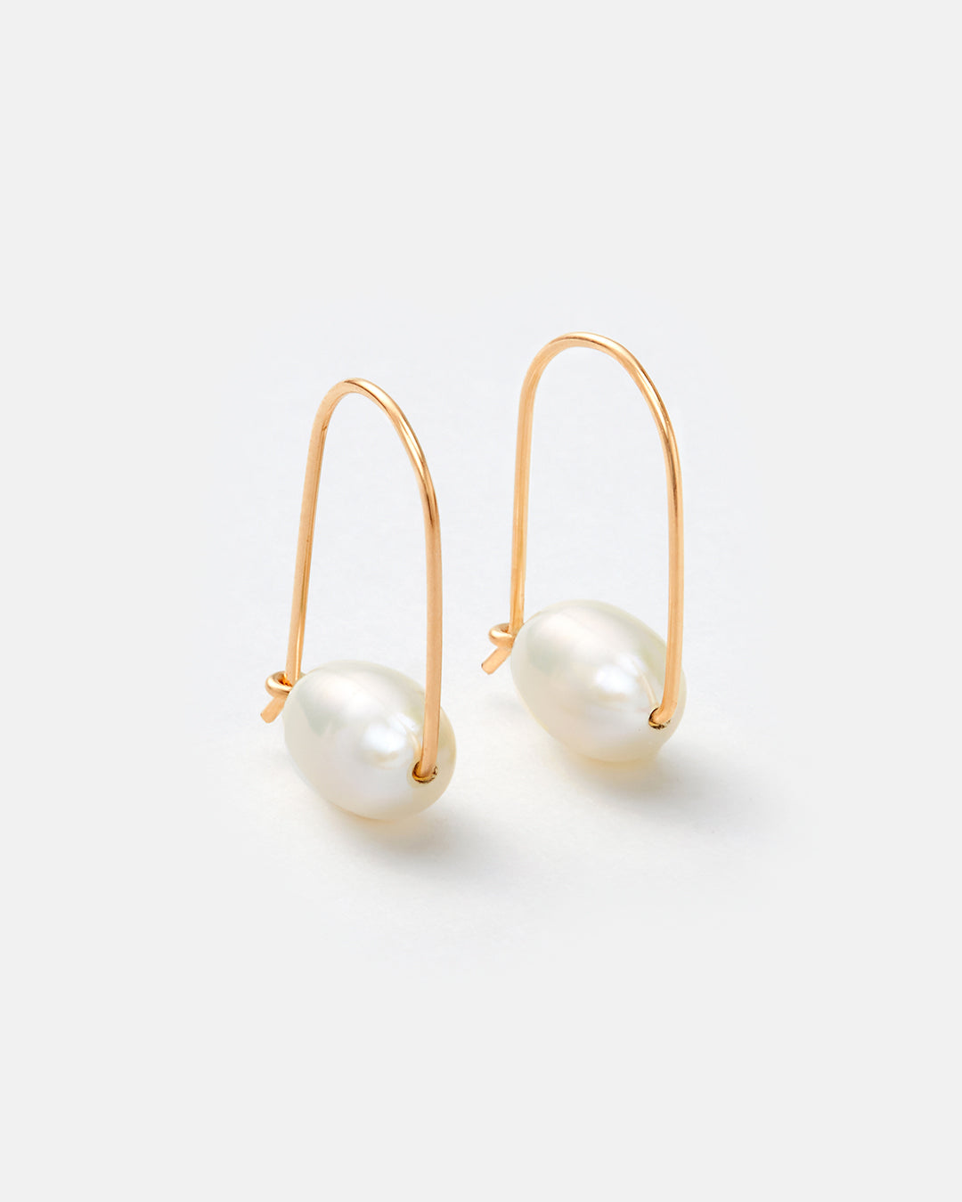 A pair of gold hoop earrings with a freshwater pearl drop, shown on a clean white background.