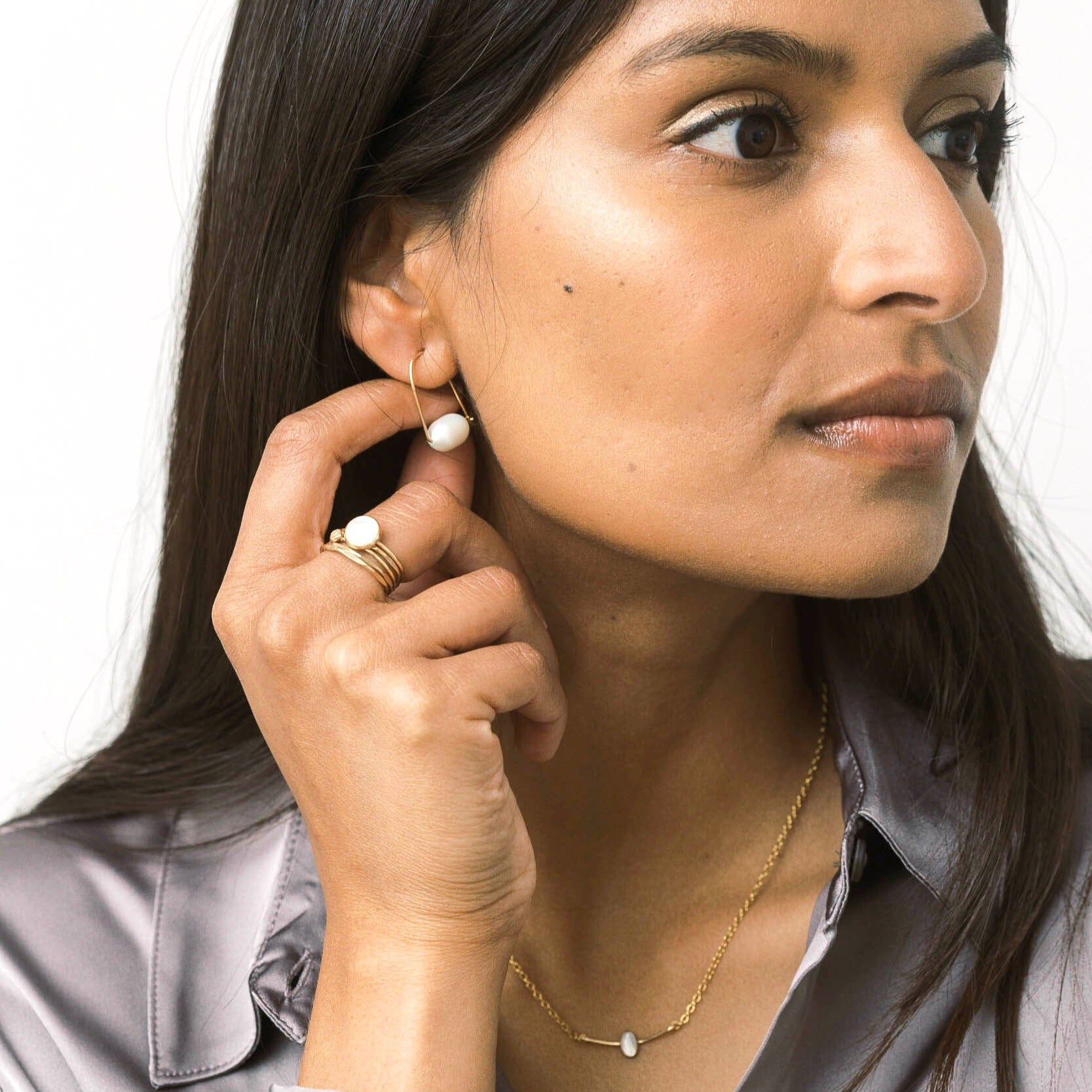 Gold pearl hoop earrings for work that are lightweight. Modern pearl hoop style.