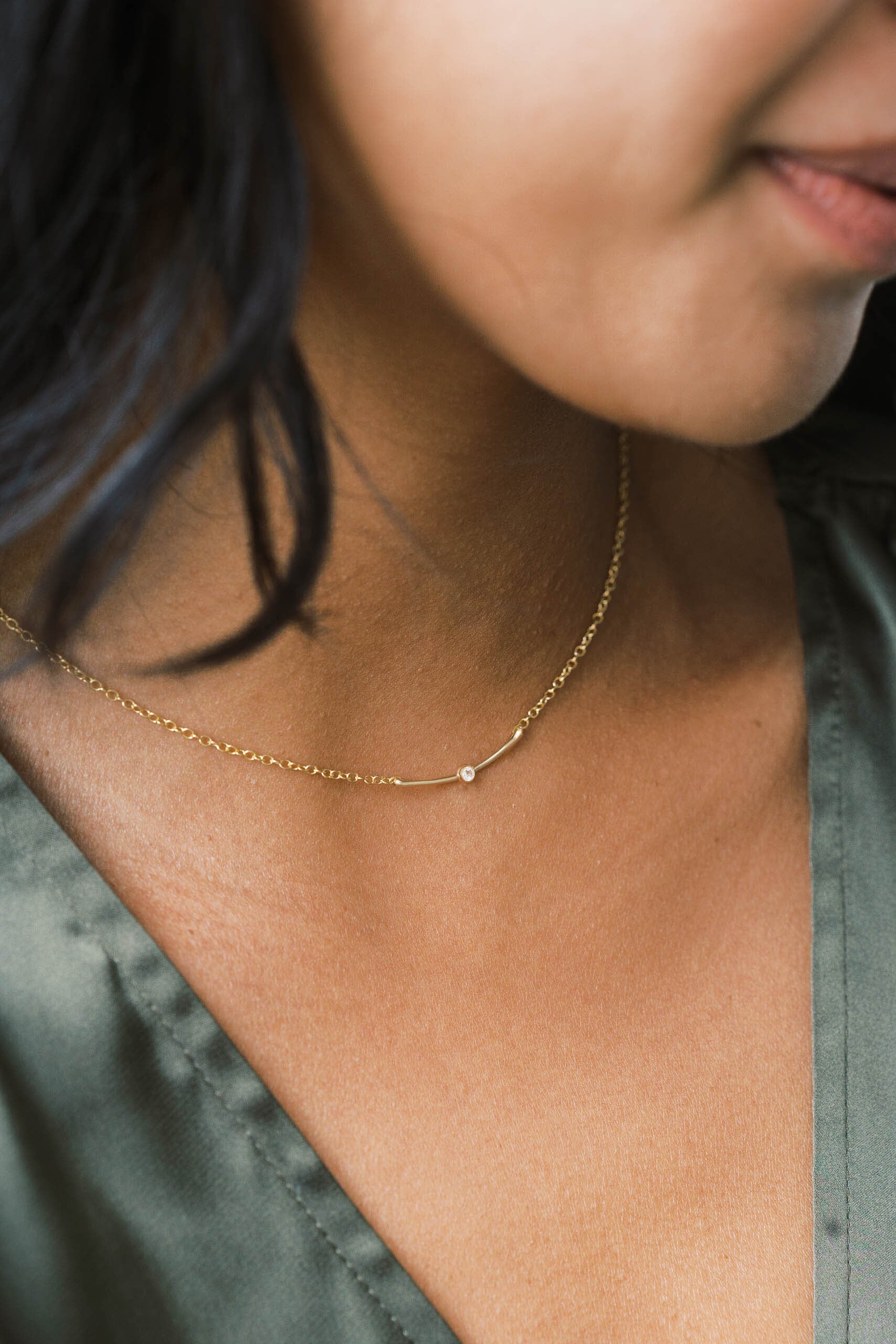 Minimal modern dainty necklace style with a small bar pendant and gemstone.