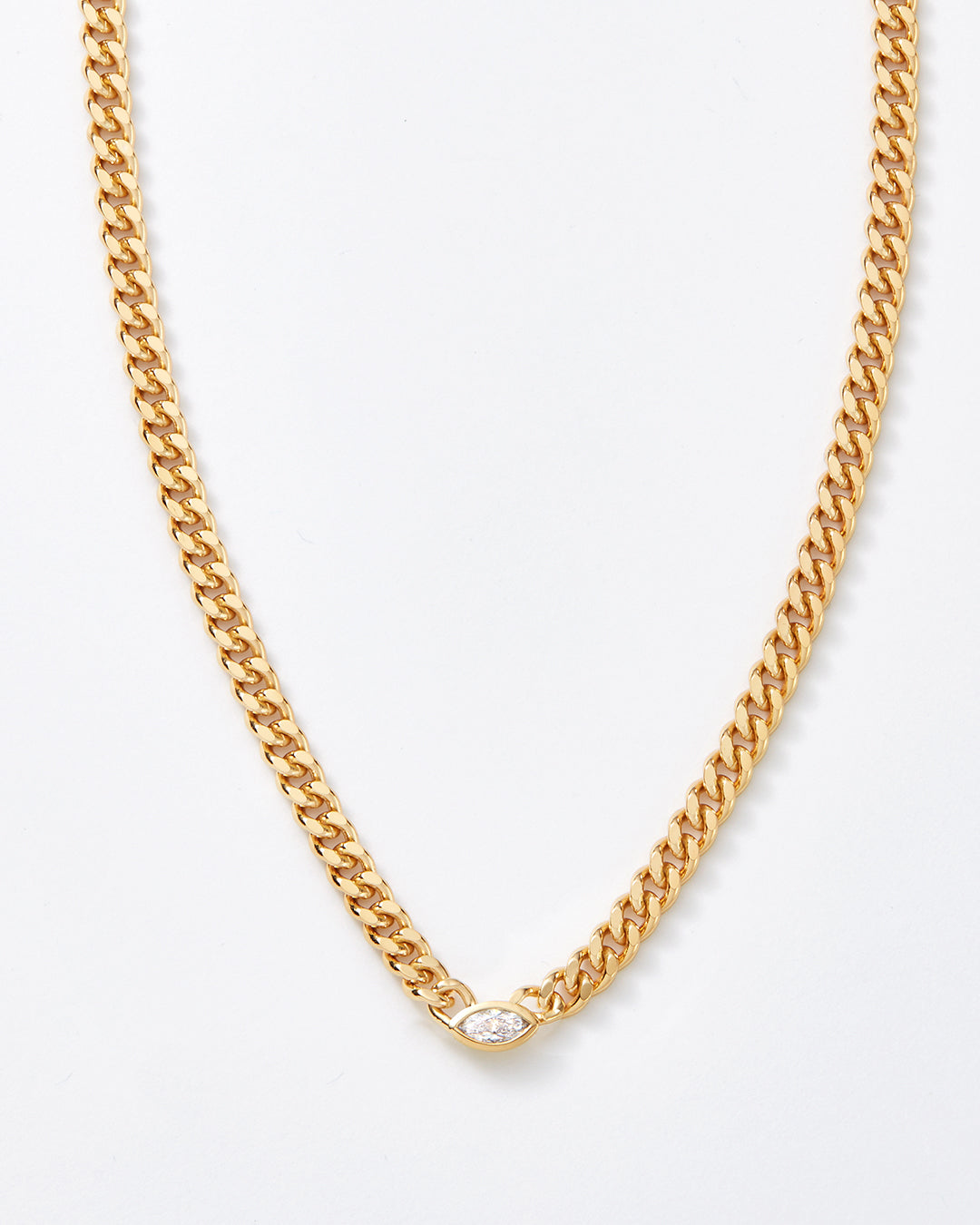 A gold-toned curb chain necklace with a small marquise-cut clear gemstone accent at the center, displayed against a clean white background.