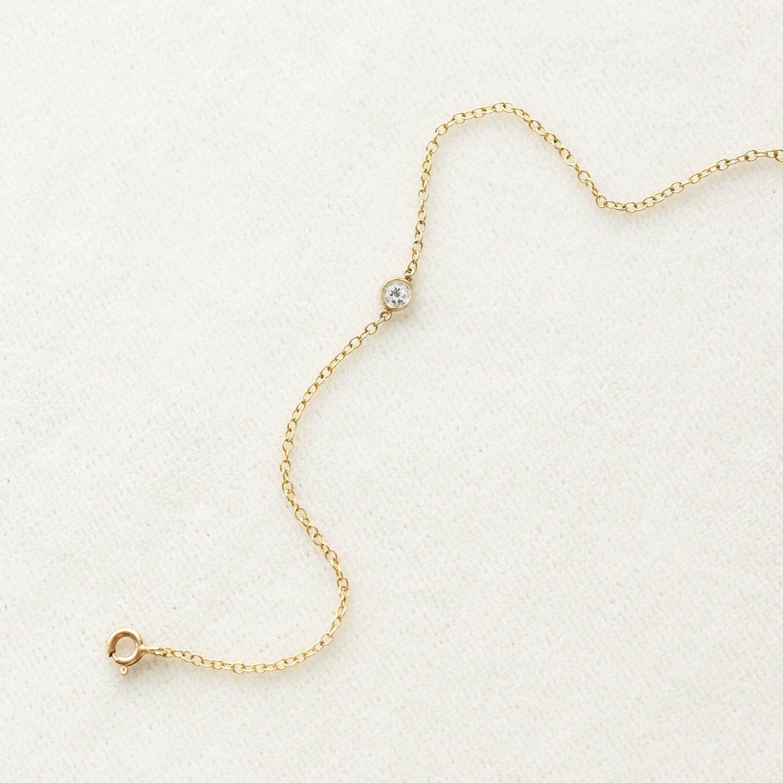 thin delicate gold bracelet with white topaz gemstone