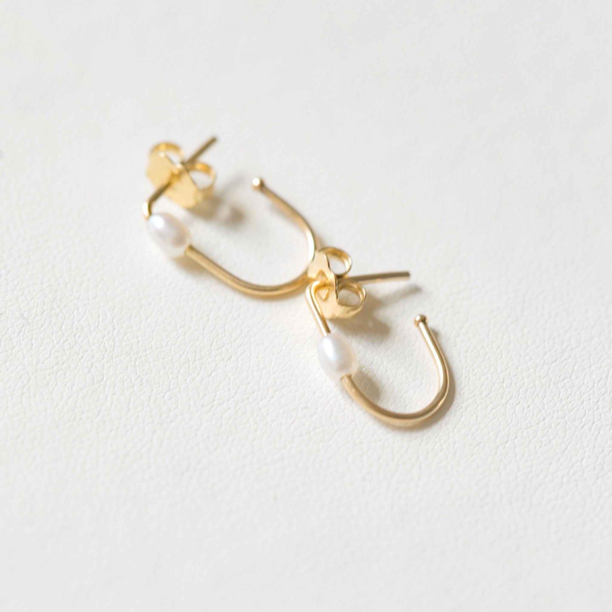 Oval pearls on an oval shaped hoop earring. The earring is made with recycled gold and sustainably sourced pearls.