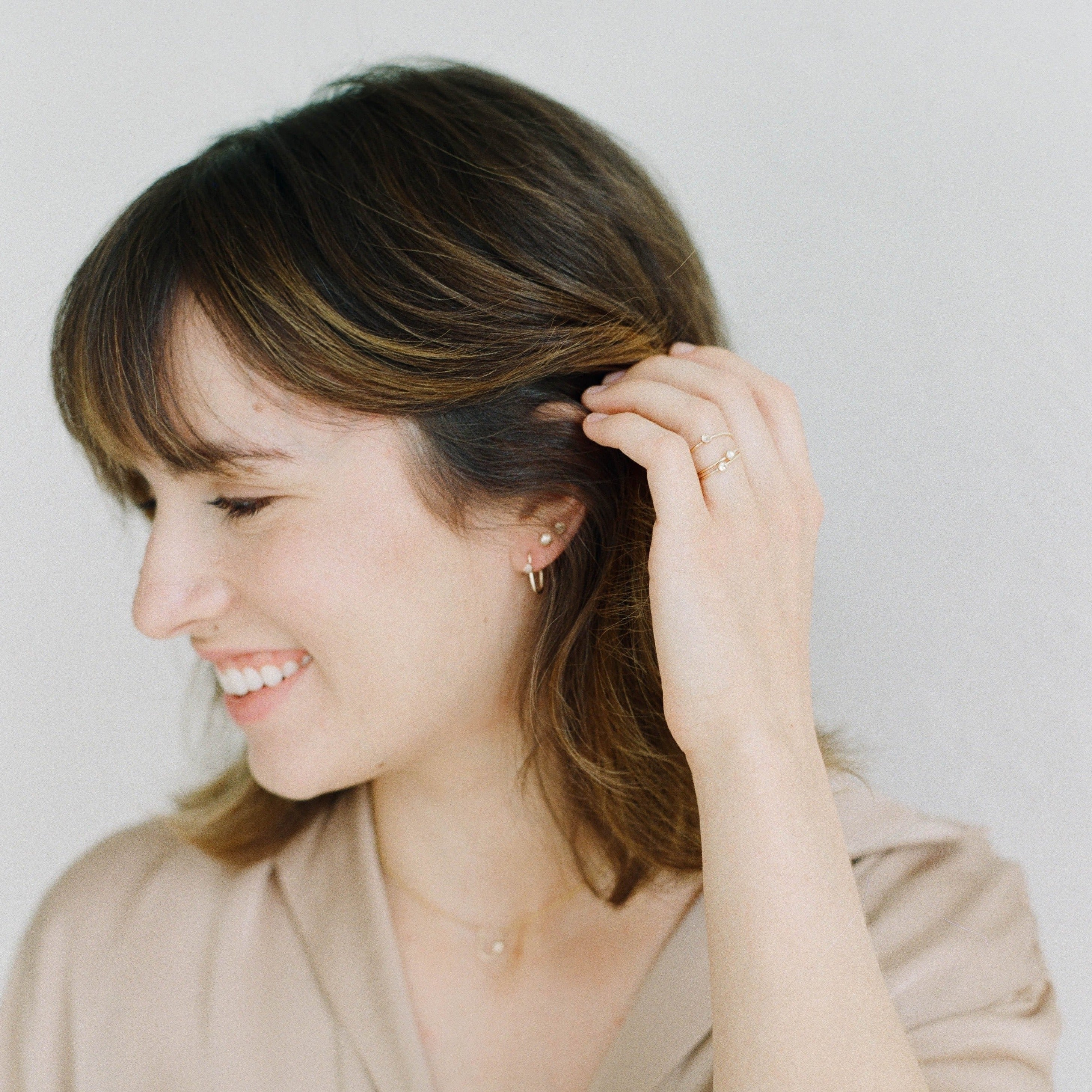 Small delicate gold hoops that feel light and comfortable. Made with genuine white topaz gemstone and recycled 14k gold filled metal.