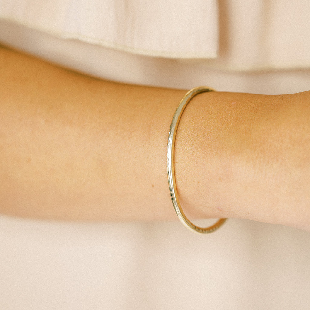 Timeless modern gold cuff bracelet with a hand hammered finish. It is adjustable by hand. You can open and close it for find a comfortable fit. It is made with recycled gold.