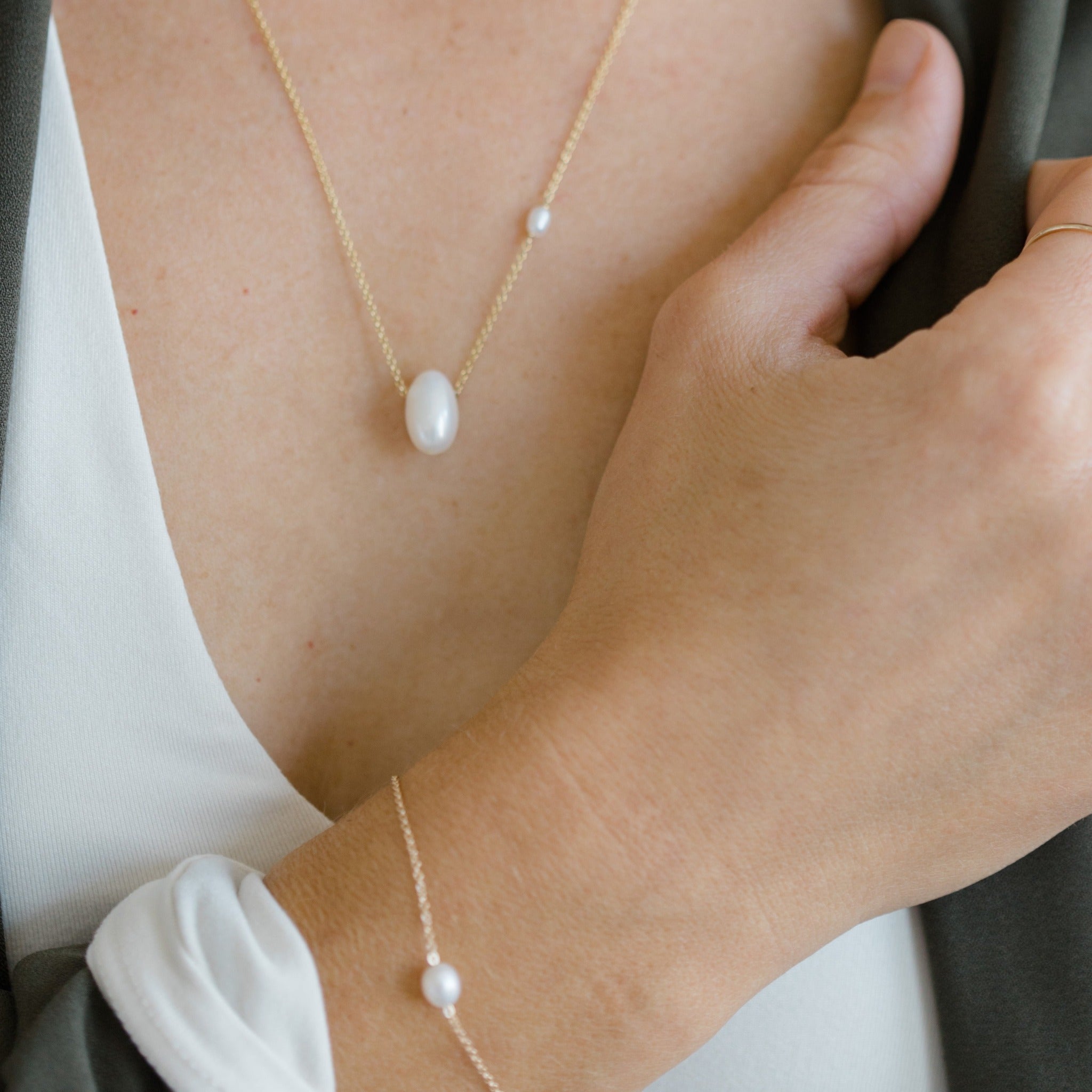 Simple pearl drop necklace with a floating pearl. White oval pearls on a 14k gold chain.