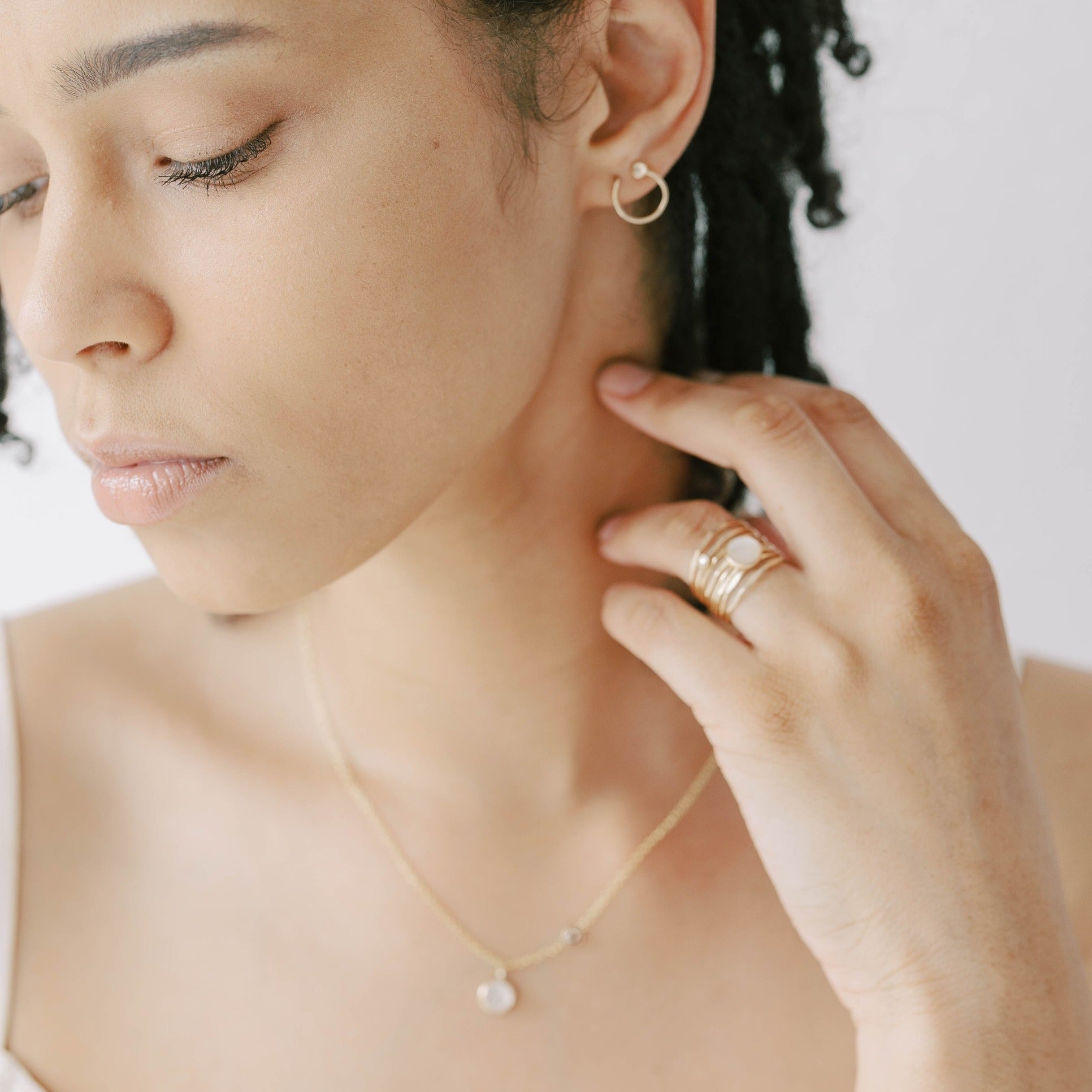 Dainty modern gold necklace with mother of pearl and white topaz stone. Pearl ring and circle stud earrings