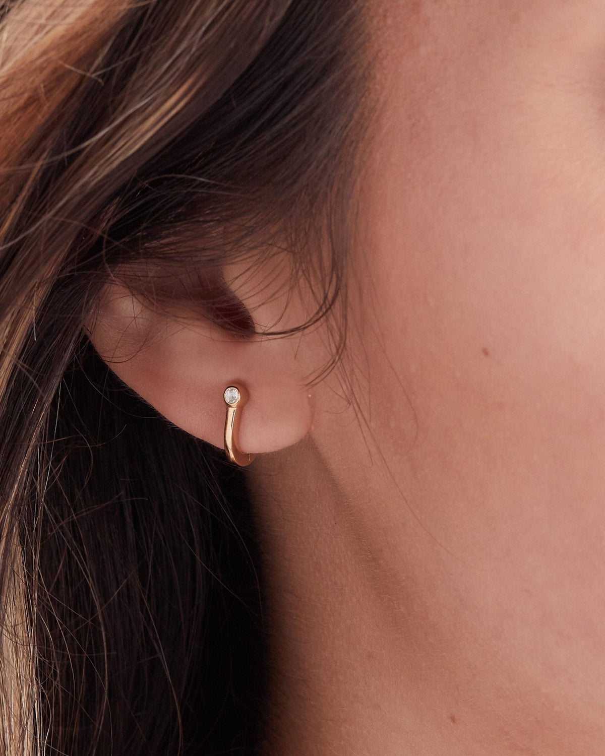 Small Gold huggie with a small white topaz gemstone