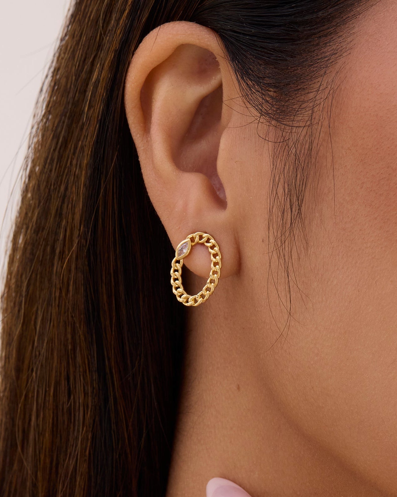 Gold Oval stud earring made with a curb chain and white gemstone