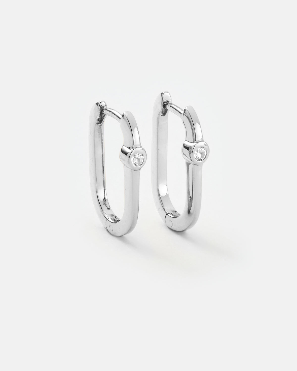 Midi reversible sterling silver hoop earrings showing the white topaz side