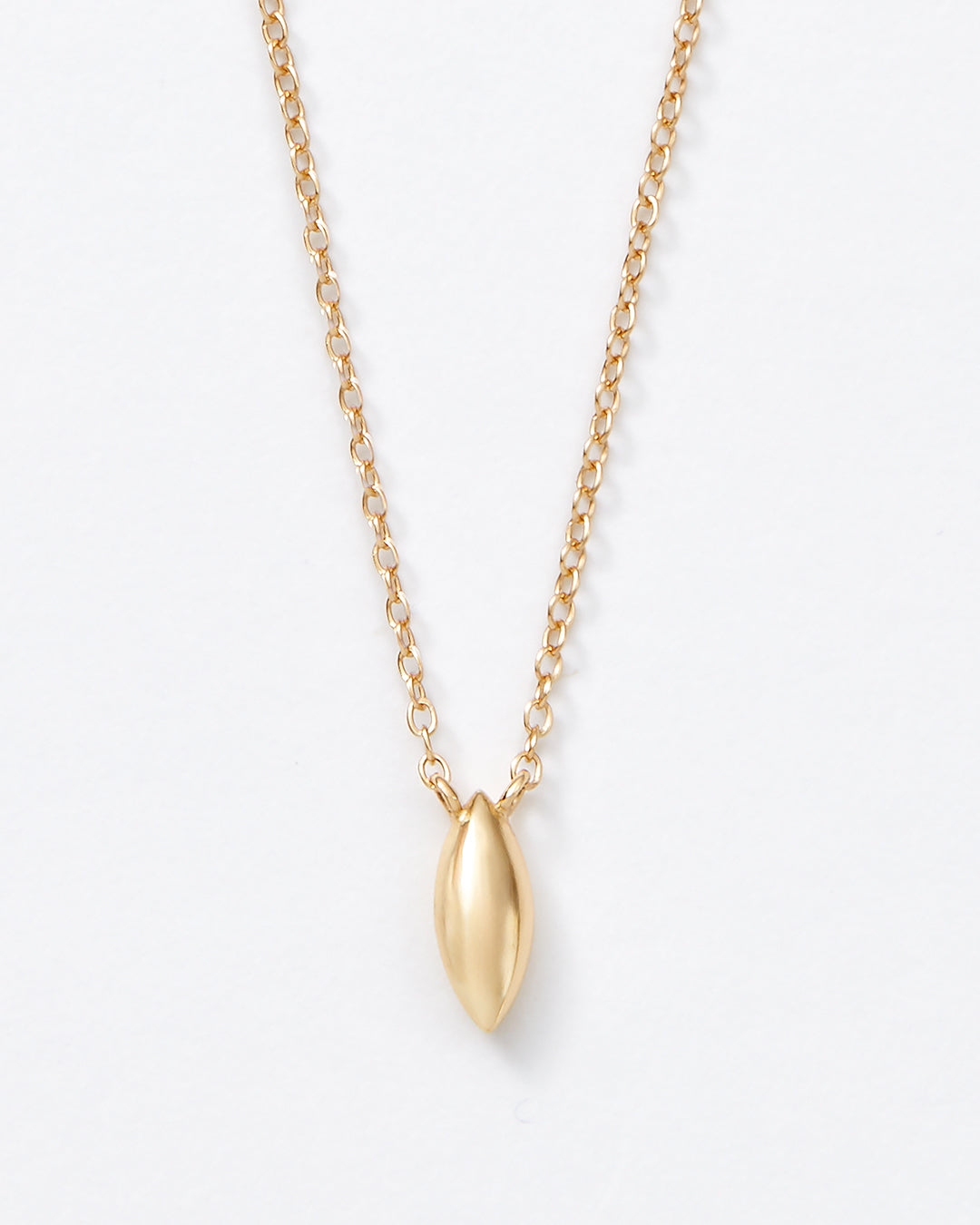 A delicate gold chain necklace with a small, polished gold teardrop-shaped pendant, shown against a plain white background.