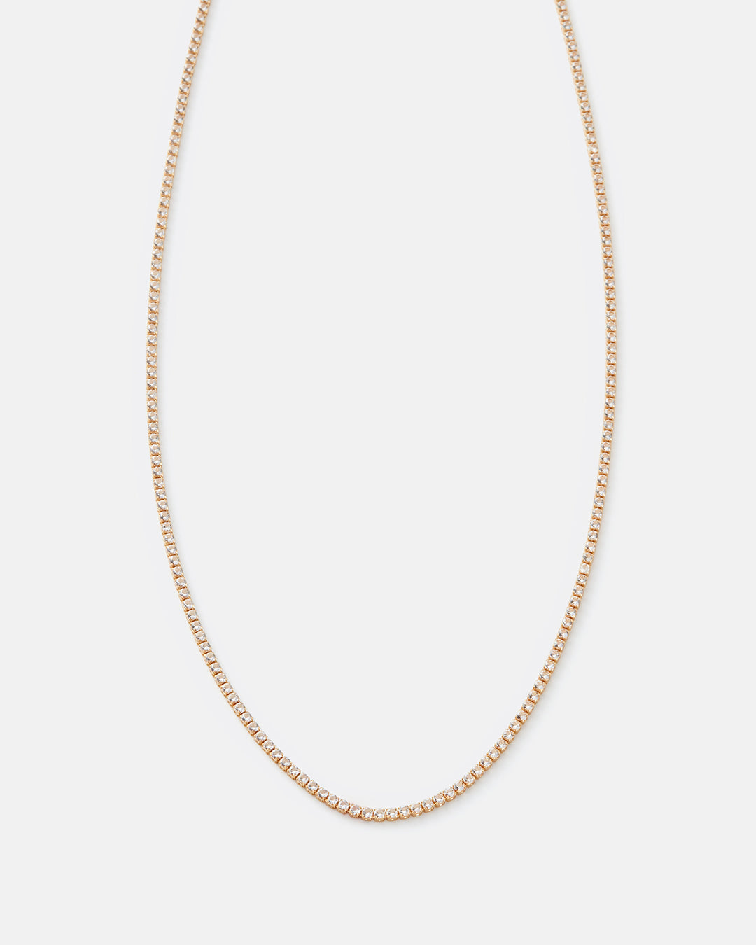 A delicate gold chain necklace with a small-scale box link design, displayed against a solid light gray background.