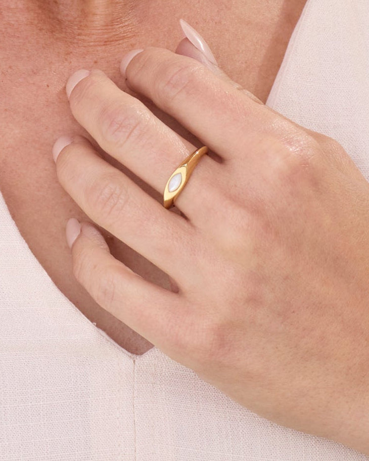 Gold signet ring with a small white pearl marquise gemstone.