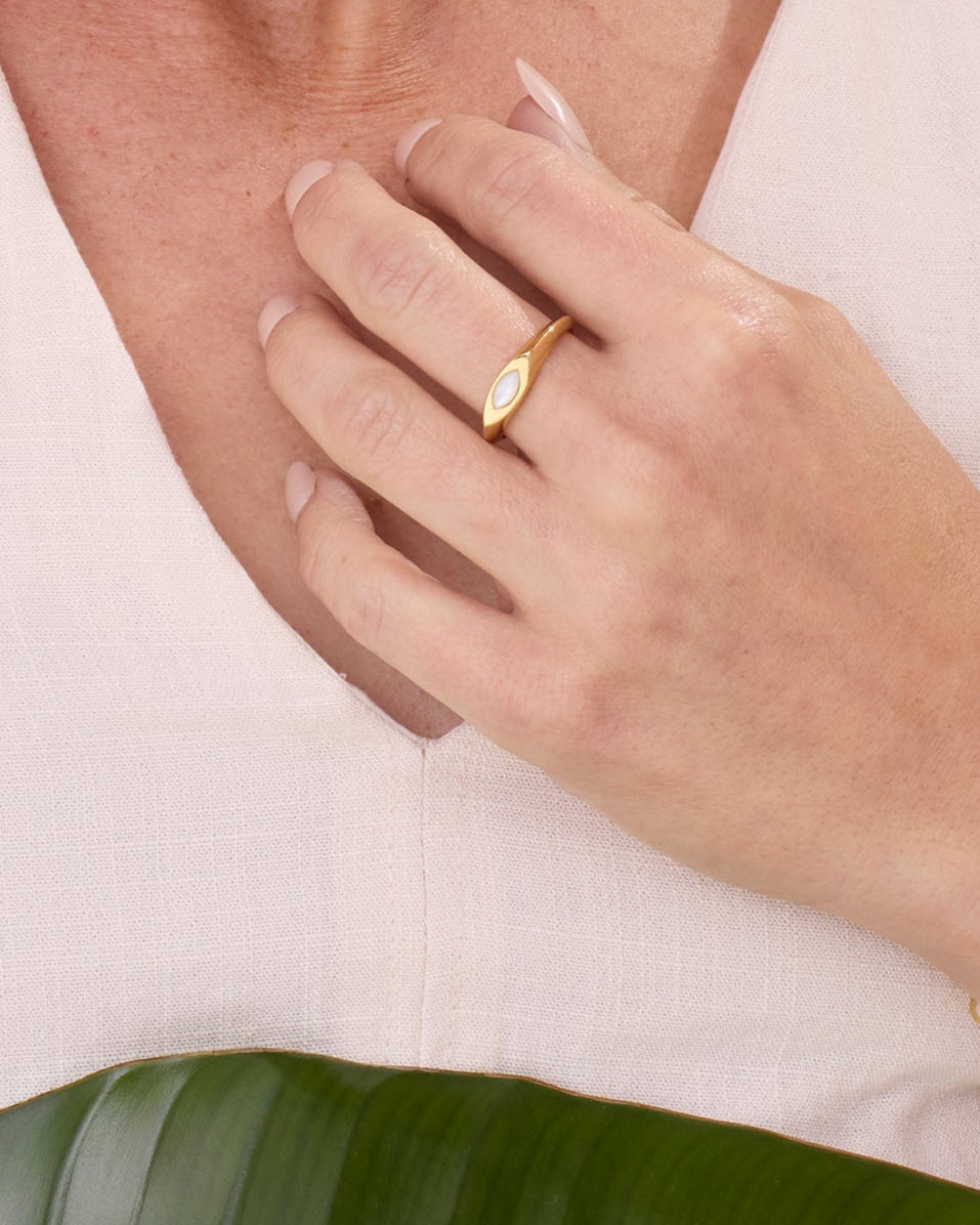 Gold signet ring with a small white pearl marquise gemstone.