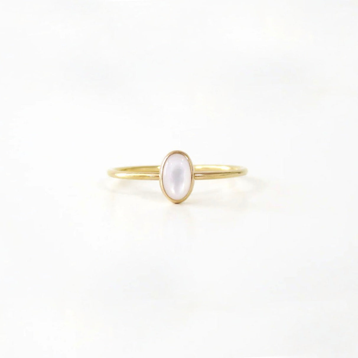 Gold ring with small oval white pearl
