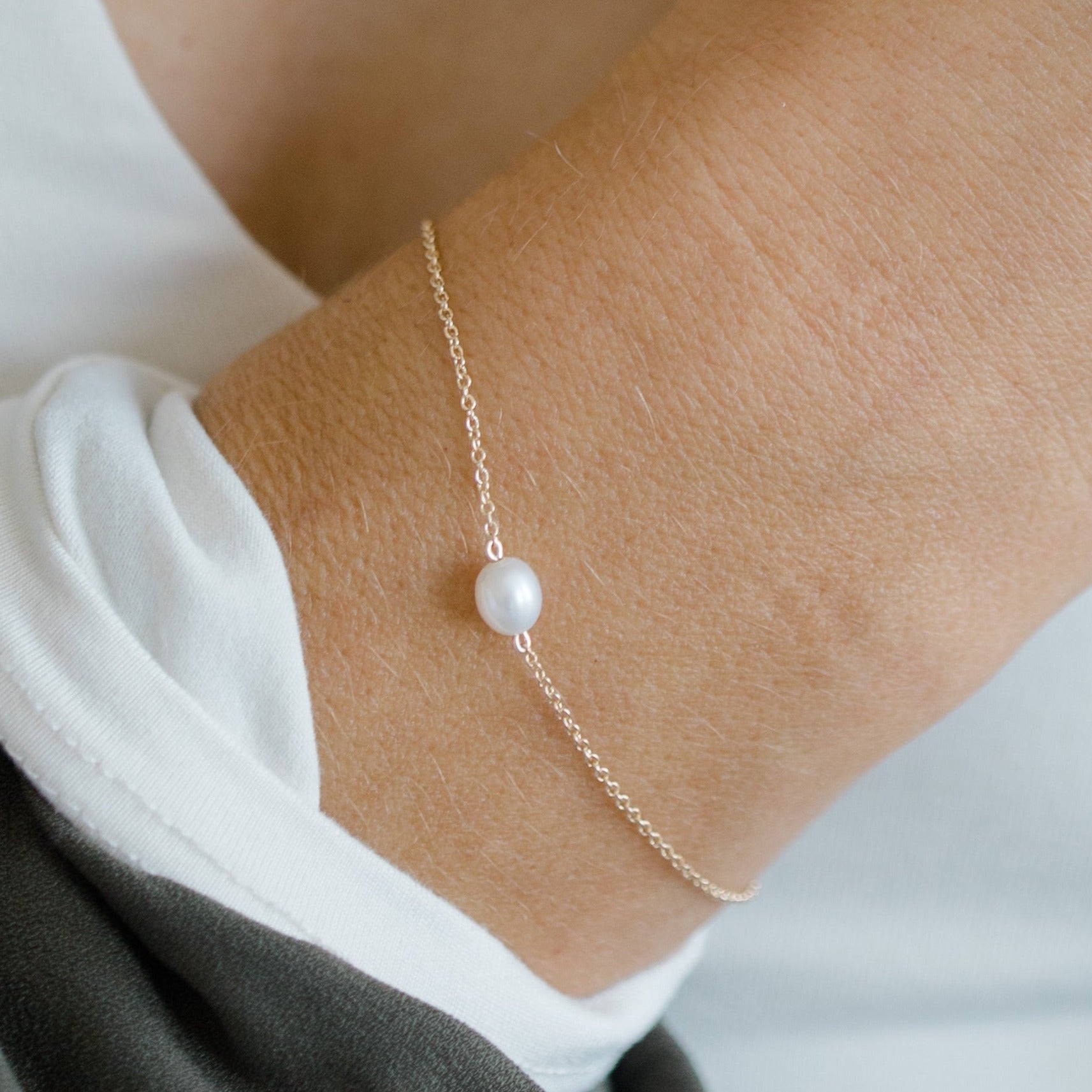 White freshwater pearl bracelet. A simple pearl floats along a 14k yellow gold chain.