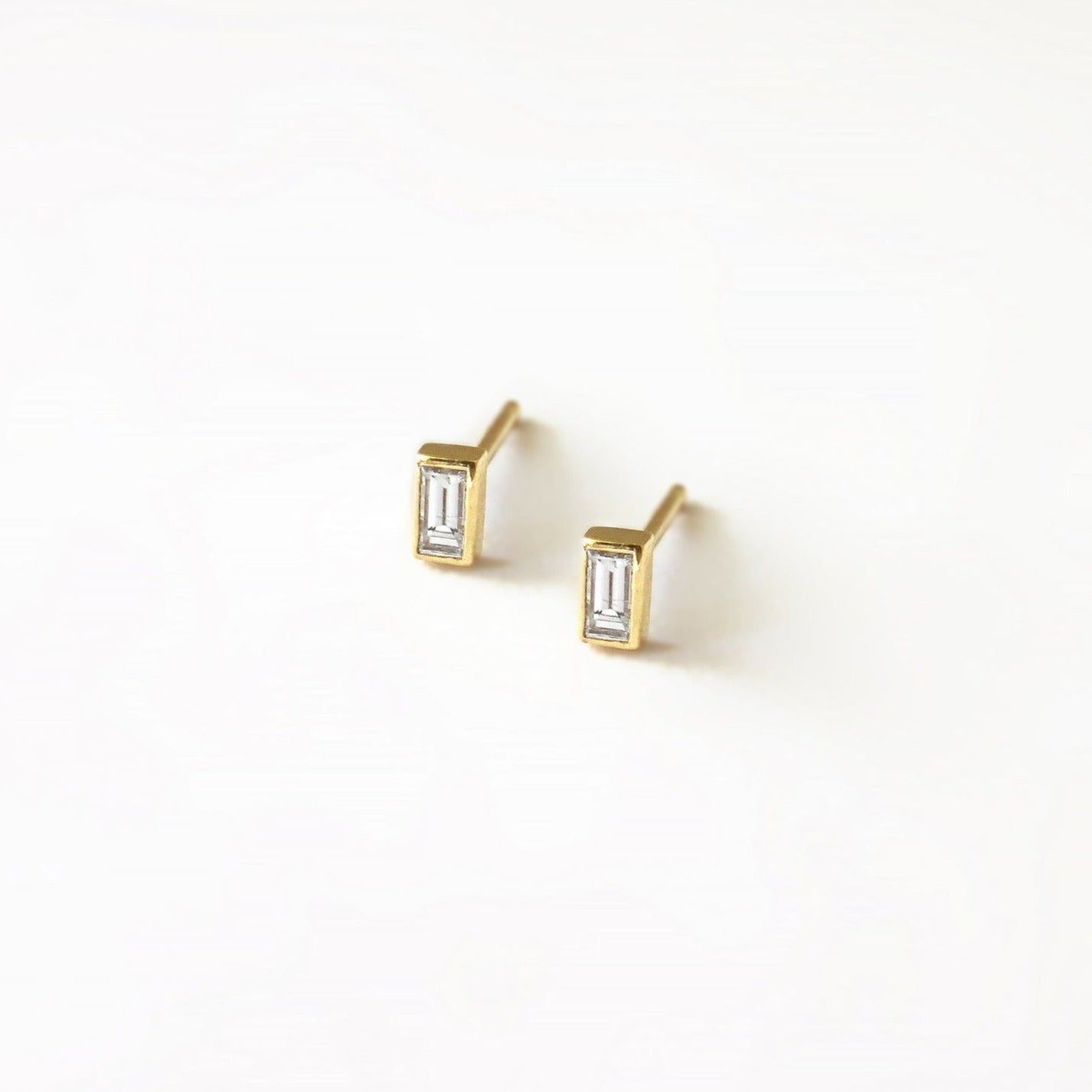 Simple small bezel set rectangular stud earrings.