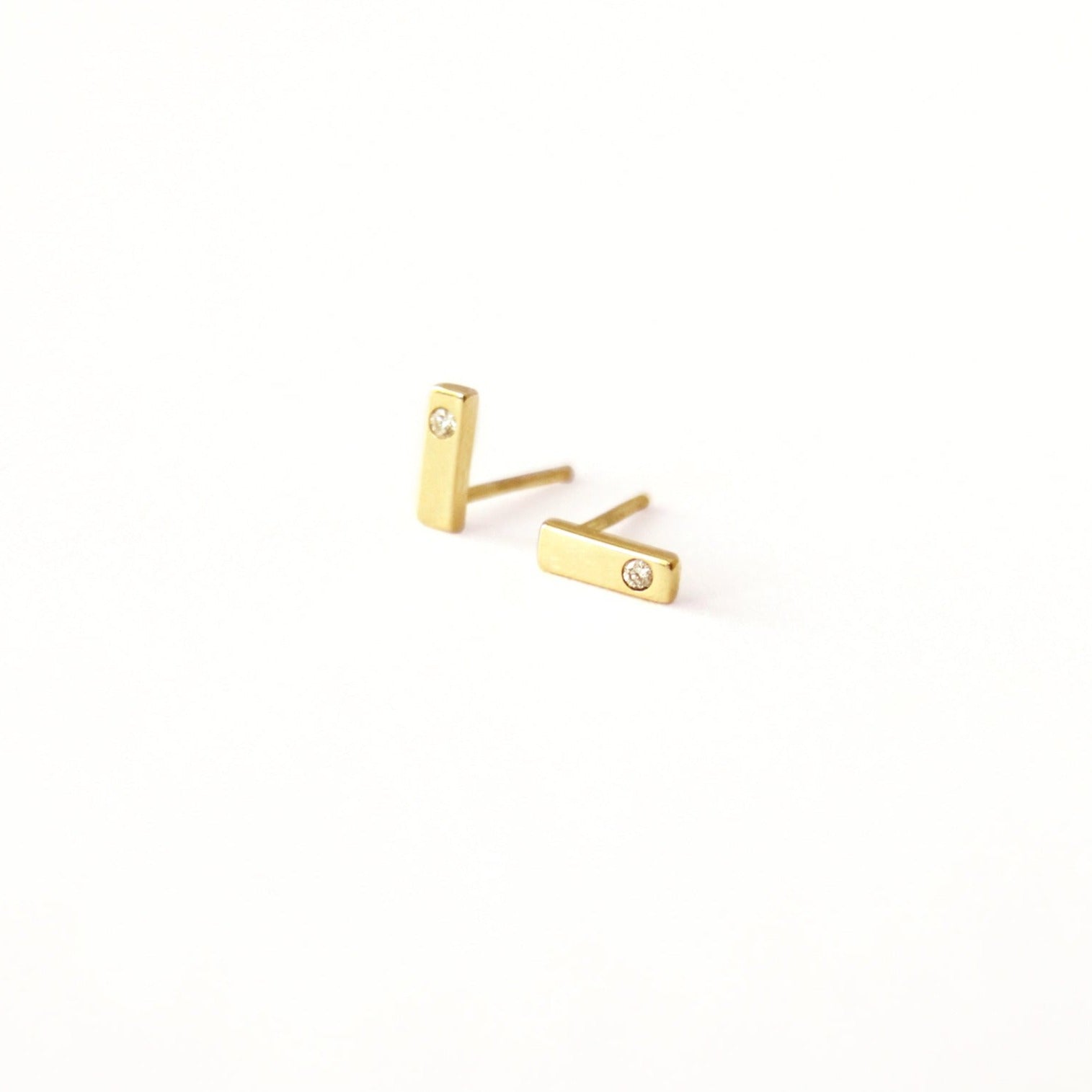 Solid gold bar stud earring with a tiny 2mm diamond. Light tiny earrings that will go with any outfit. Easy to wear everyday.