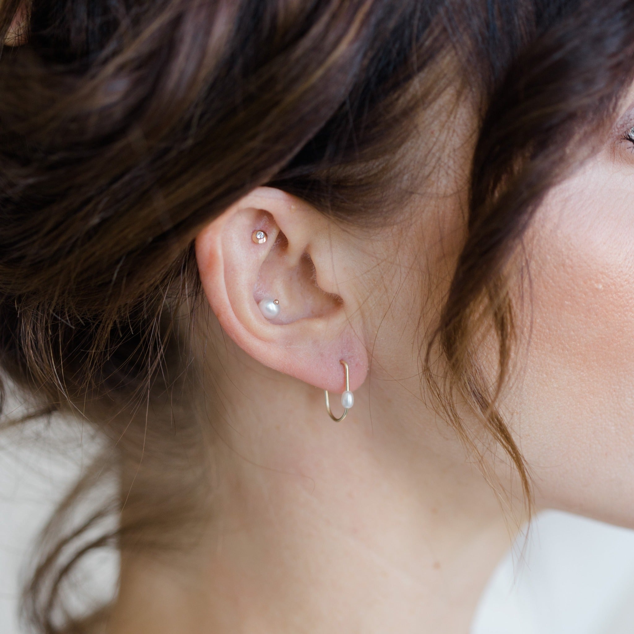 Handcrafted gold and diamond stud earrings shown with other stylish earrings. It's an ear party. Curate your own style with these simple small earrings that work together.
