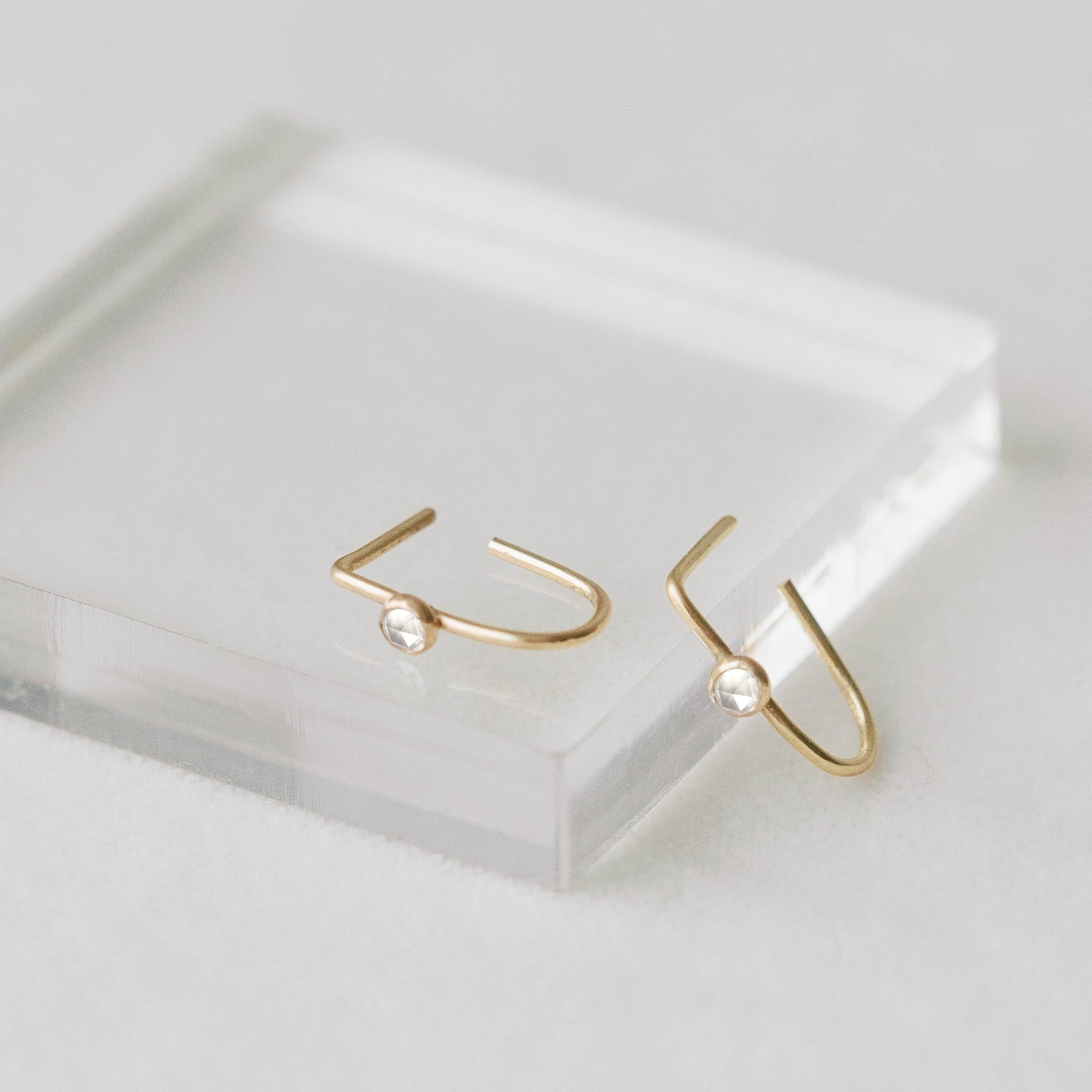 Small gold hoops made from recycled gold. Small white topaz rosecut stones.