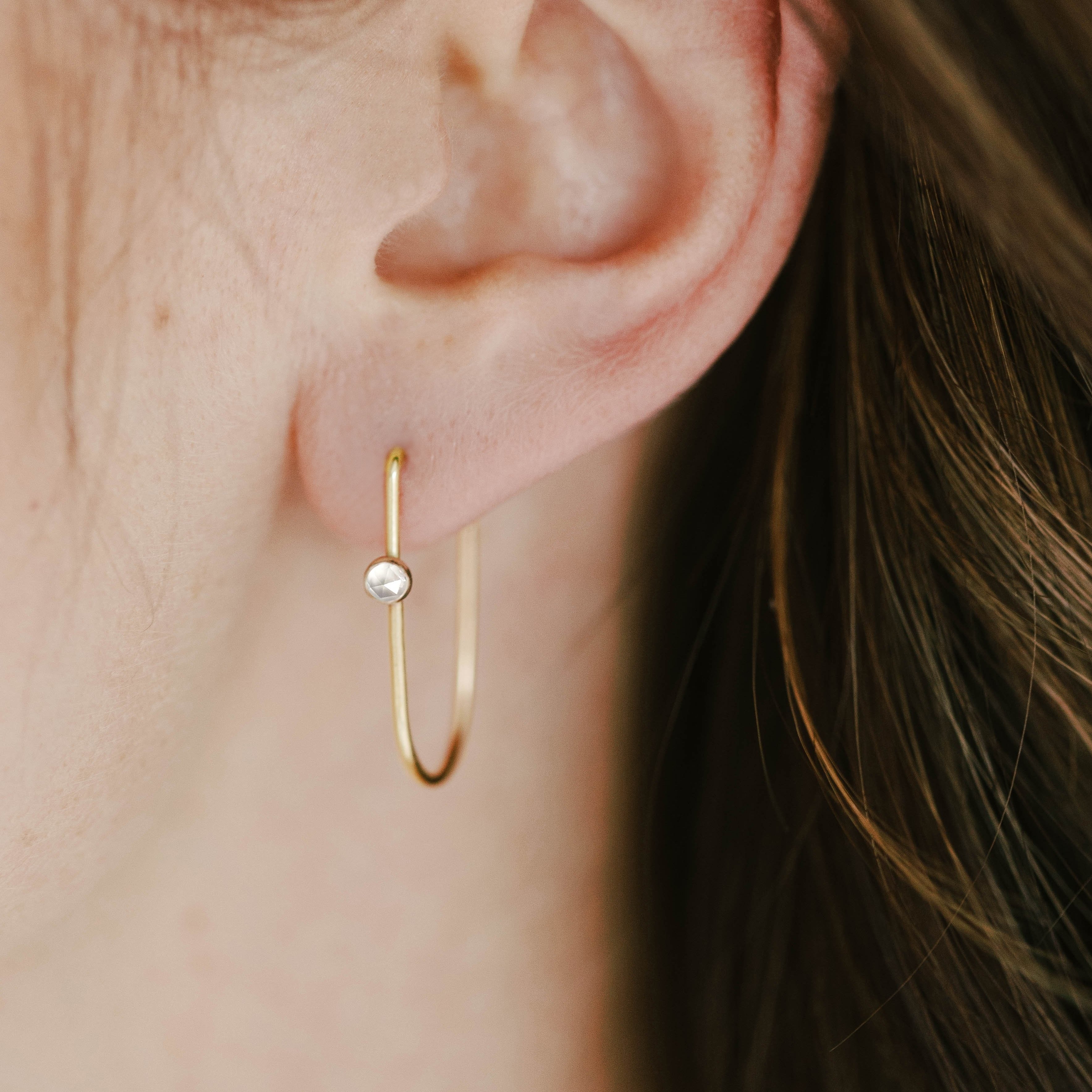 Thin gold hoop earrings with white topaz