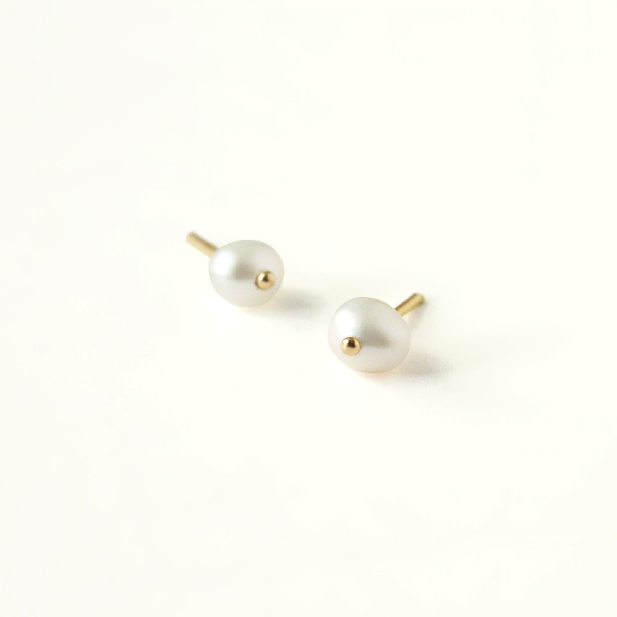 Sophisticated gold pearl stud earrings with a tiny gold ball detail. Unique design handcrafted with recycled 14k yellow gold and natural white round pearl. A timeless earring with a minimal and modern touch. 