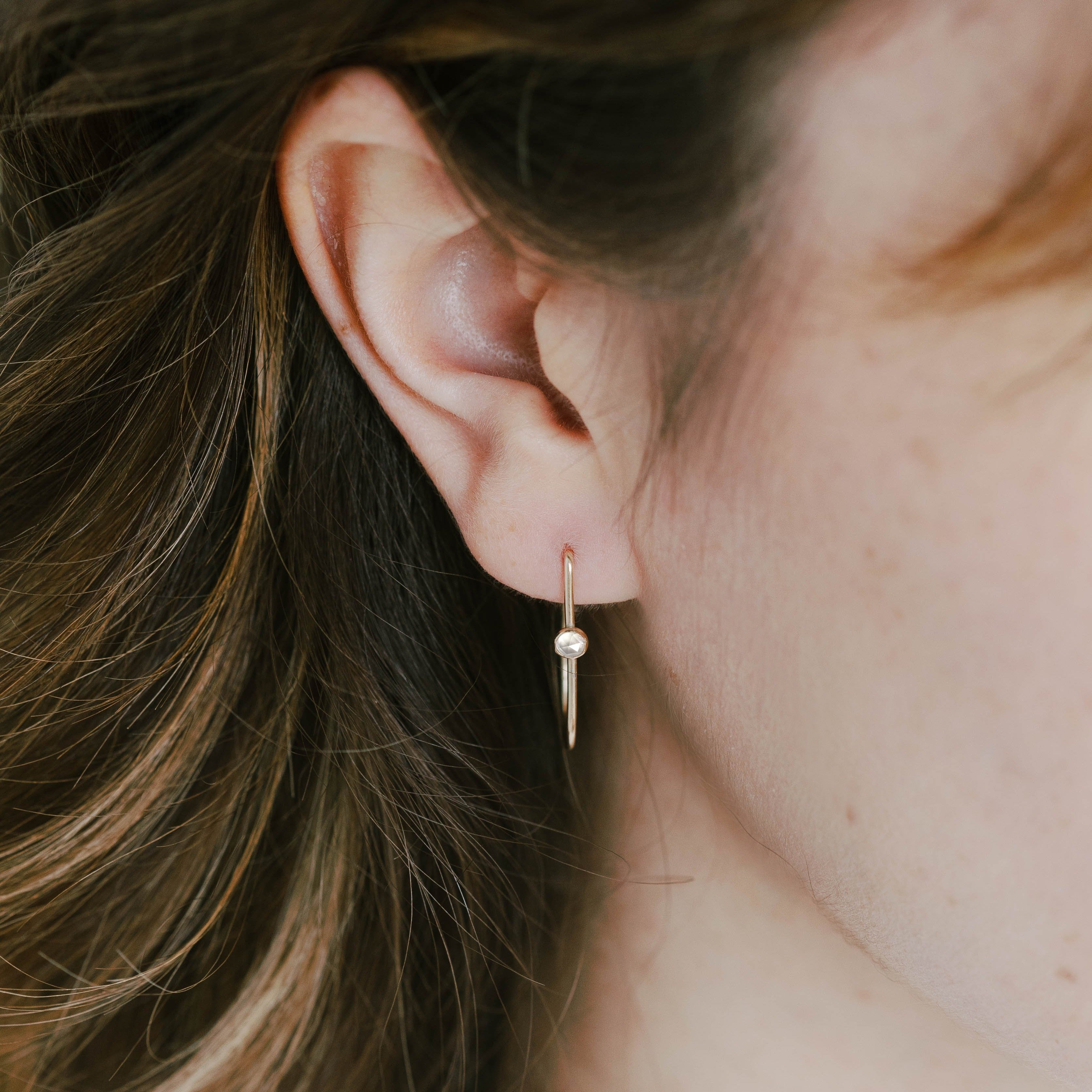 Delicate gold hoop earrings made with a small 3mm white topaz gemstone and recycled 14k yellow gold. These are perfect to wear for any occasion.