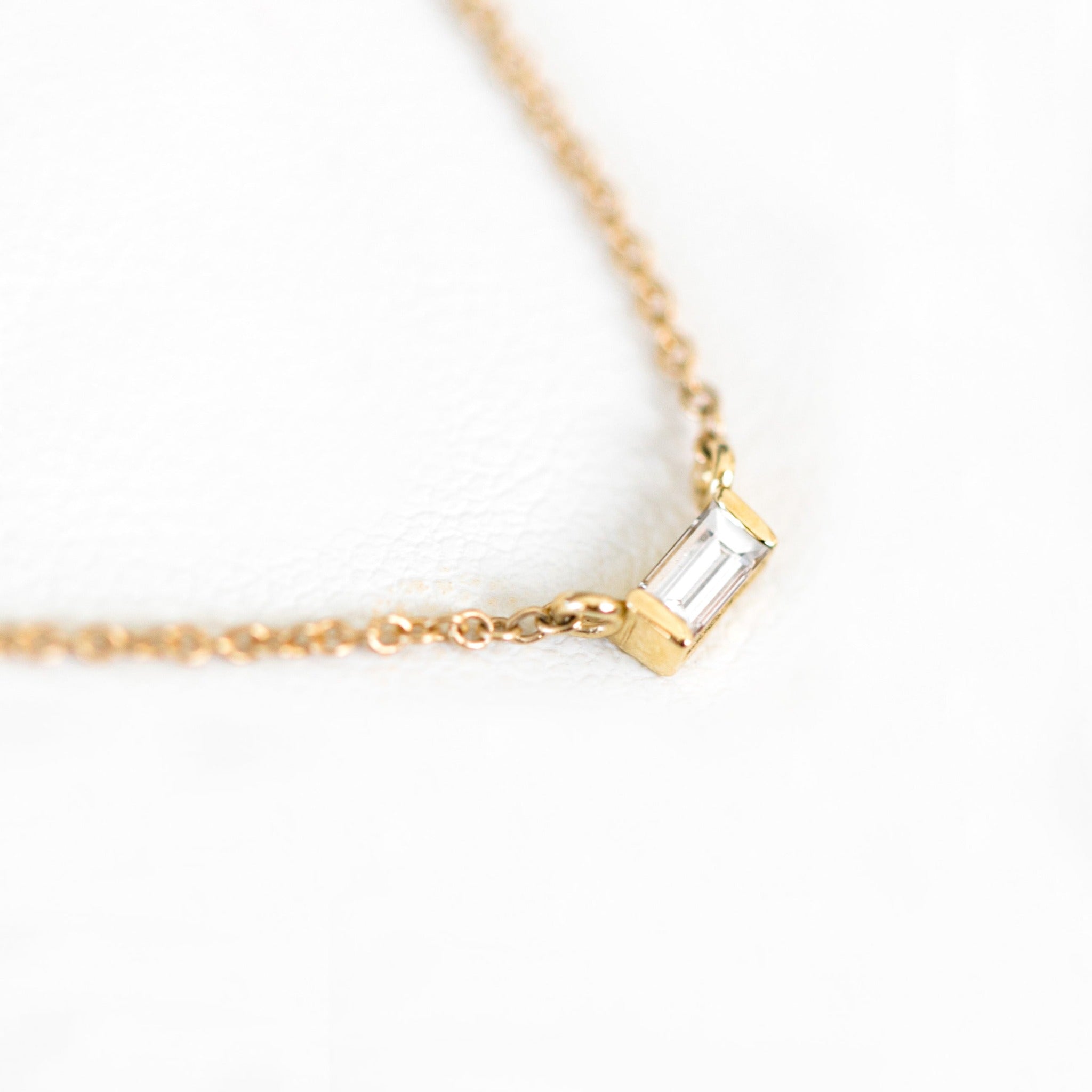 Step cut gemstone that is ethically sourced. Set on a 14k yellow gold chain.