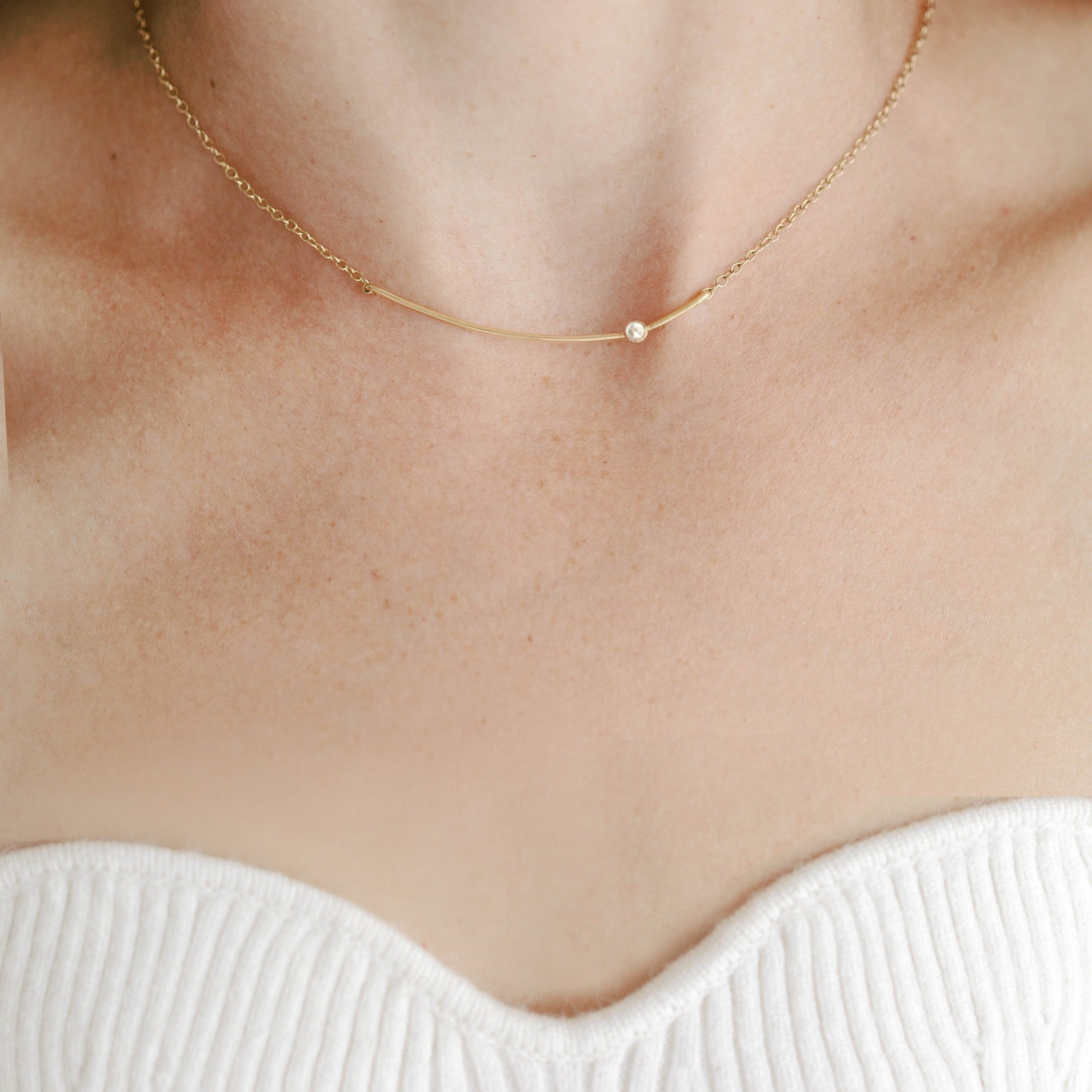 Gold curved bar necklace with white topaz gemstone