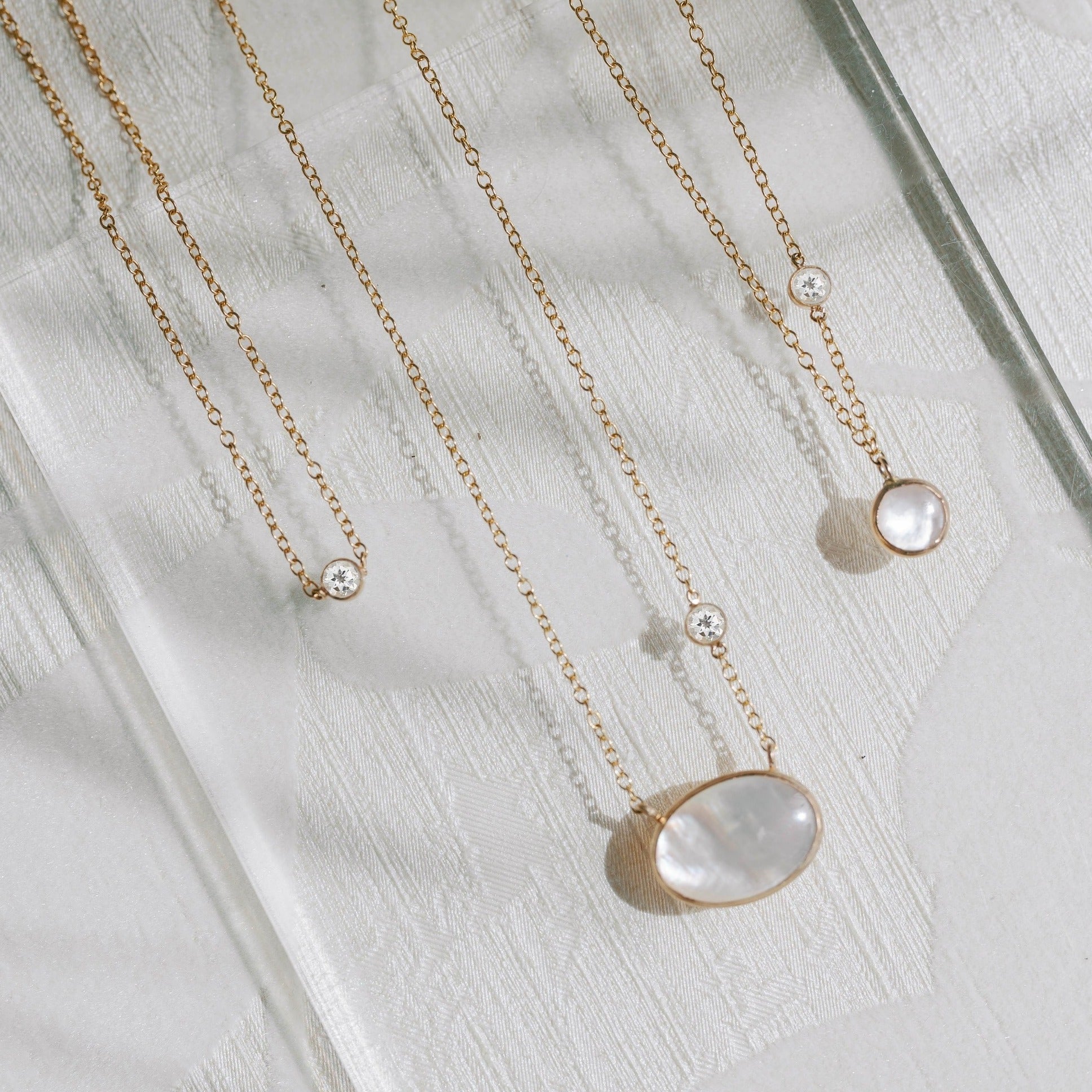 Mother of pearl pendant necklaces and white topaz gemstones. all recycled gold necklaces