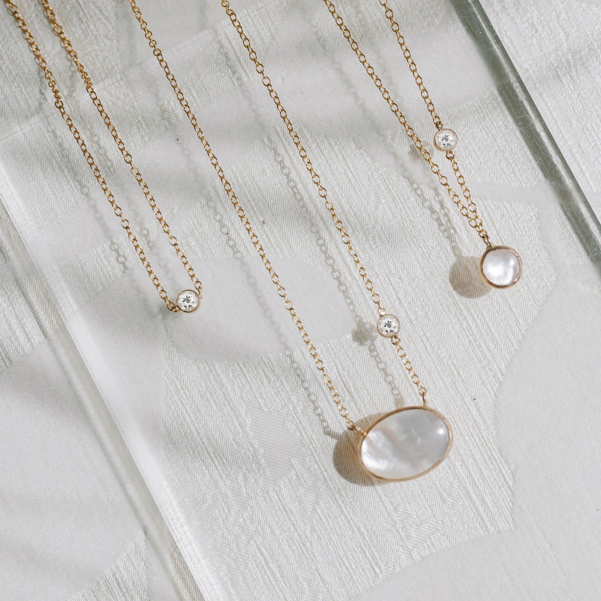 White topaz and mother of pearl necklaces made with recycled gold