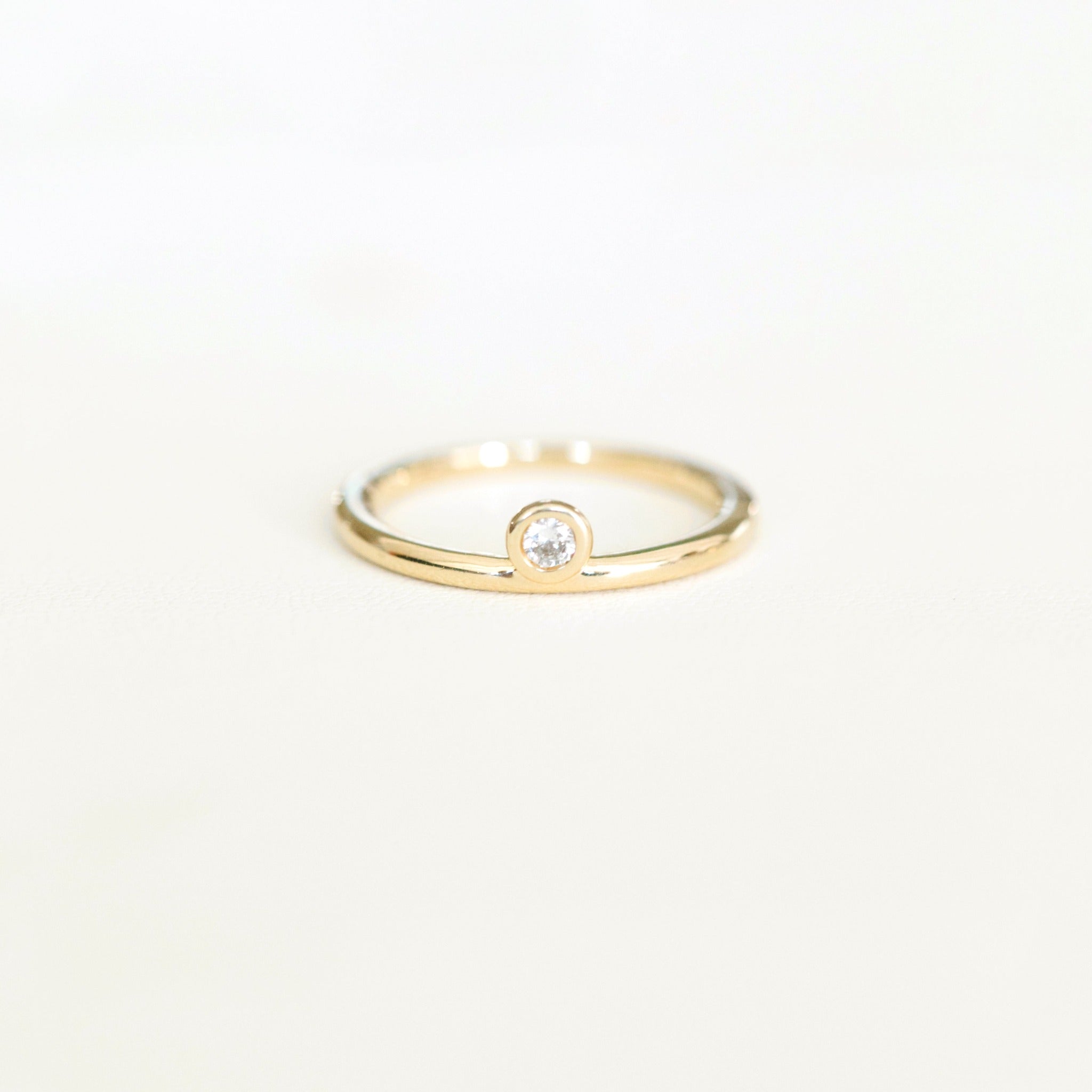 3mm diamond ring. The bezel set diamond is offset making it asymmetrical and unique. The diamond is brilliant cut.