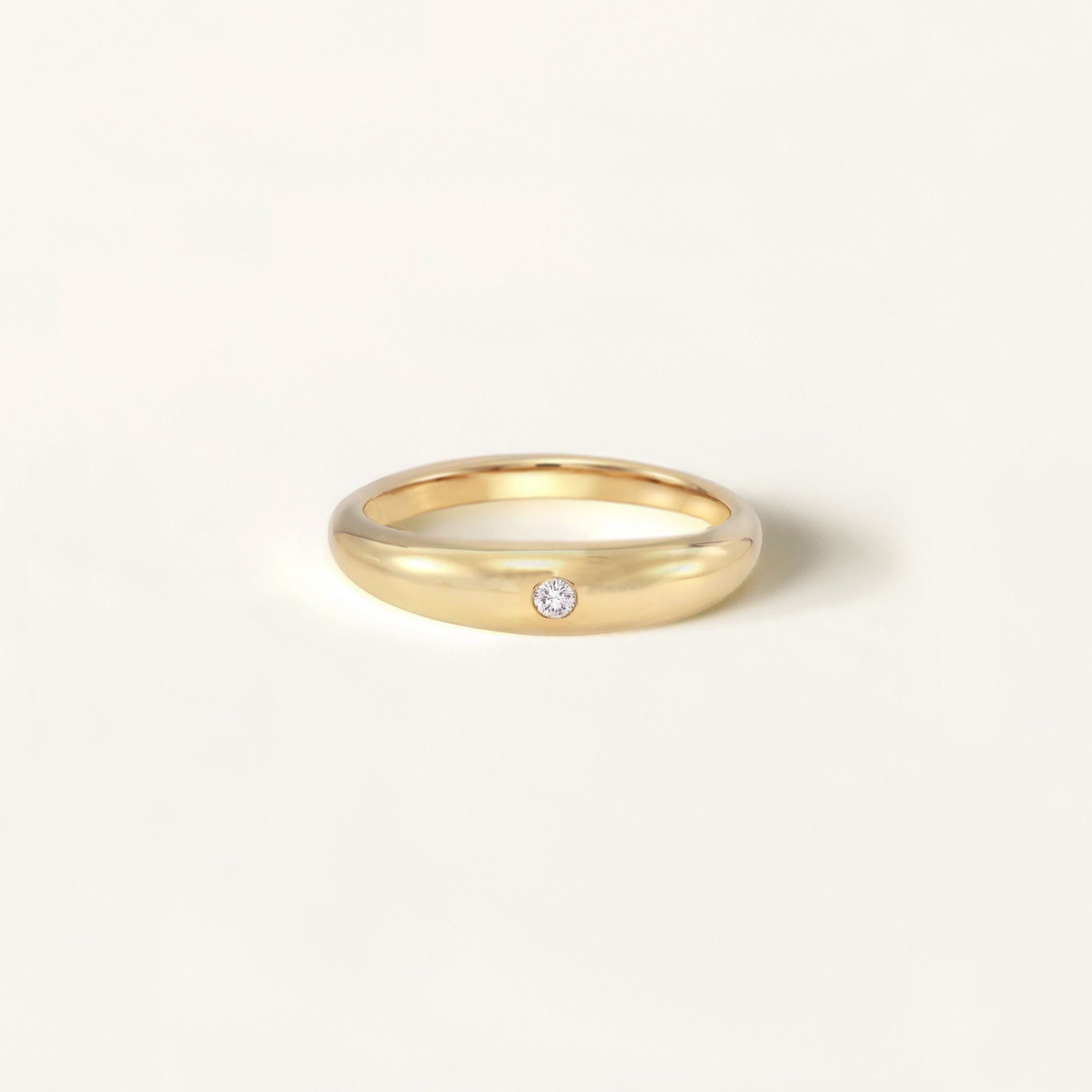 Smooth 14k gold dome ring with a flush set diamond. Responsibly sourced diamond and recycled 14k yellow gold.
