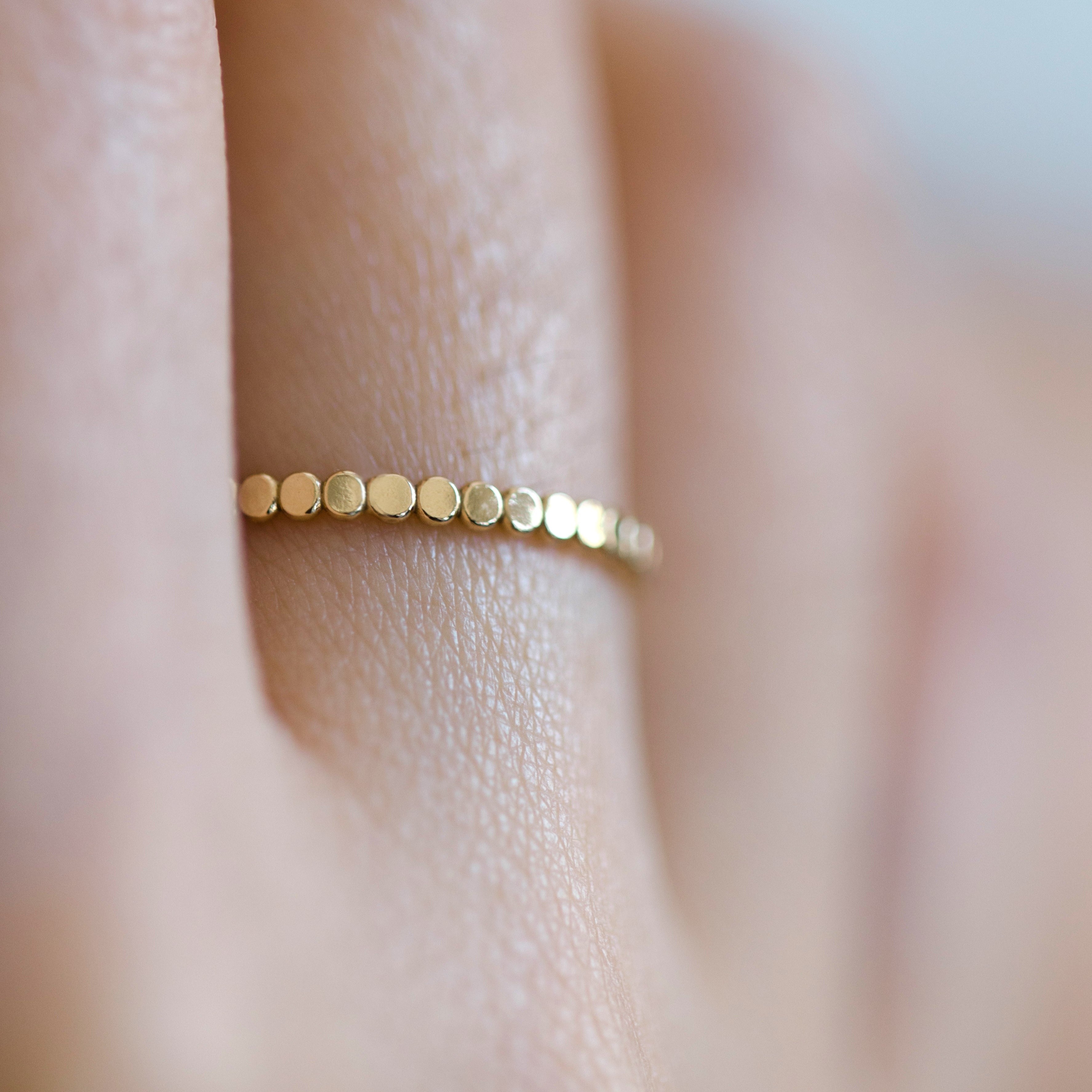 Slim gold band made with tiny dot pattern. The pattern wraps around the entire ring. Beautiful alone or stacked with other gold rings.