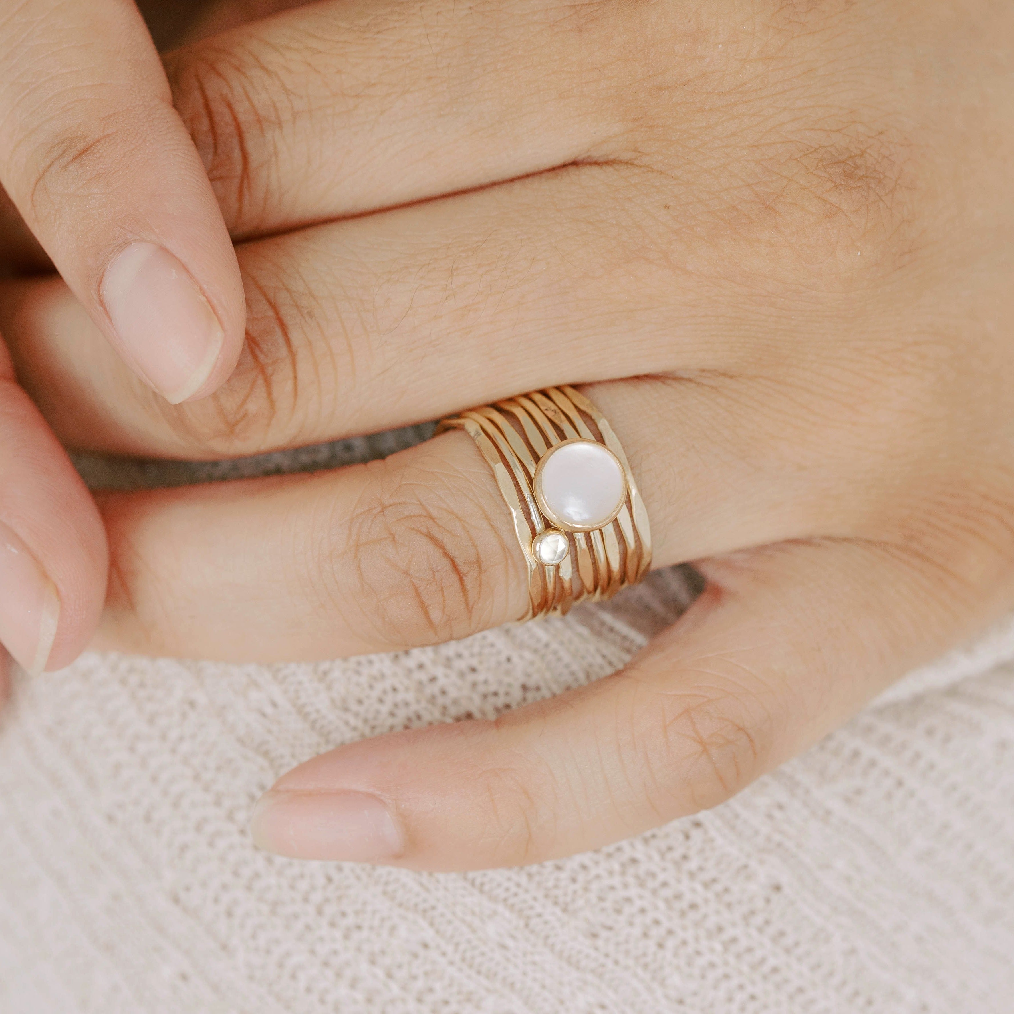 Thin gold dainty rings made with recycled gold. Little hammered gold bands are stackable. Shown here with stacking pearl ring and stacking tiny white topaz ring. 
