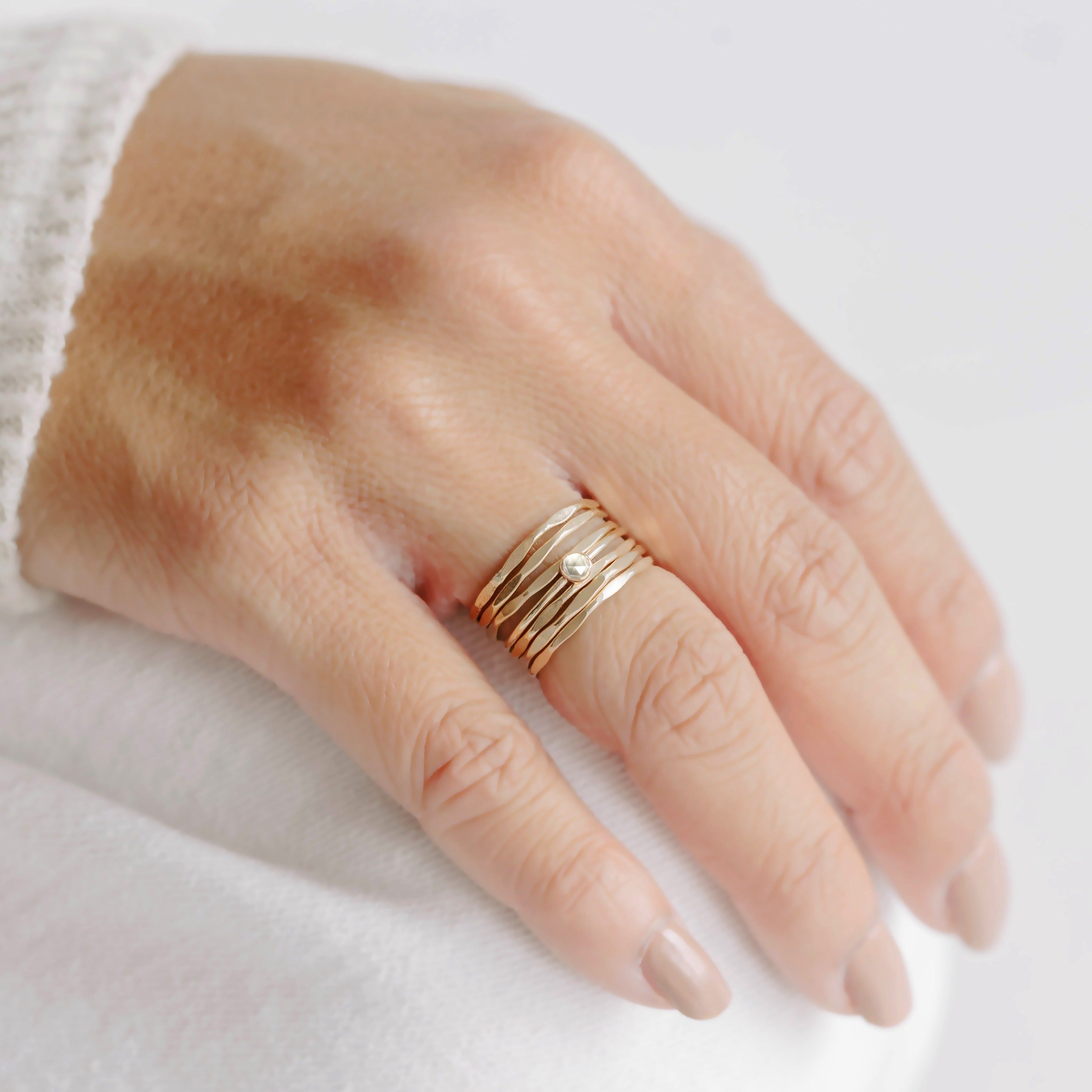 Thin and dainty gold hammered rings perfect for stacking. Tiny white topaz gemstone ring stacks well with thin gold bands.